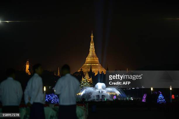 People stand as they attend a flag-raising ceremony to mark Myanmar's 65th Independence Day at the People's Square near Shwedagon pagoda in Yangon...