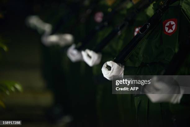 Guards of honour stand at attention during a flag-raising ceremony to mark of Myanmar's 65th Independence Day at the People's Square near Shwedagon...