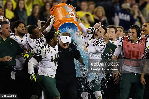 Michael Clay and Bryan Bennett dump the gatorade cooler on head coach Chip Kelly of the Oregon Ducks after their 35 to 17 victory over the Kansas...