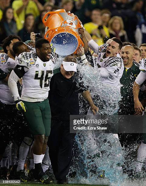 Michael Clay and Bryan Bennett dump the gatorade cooler on head coach Chip Kelly of the Oregon Ducks after their 35 to 17 victory over the Kansas...