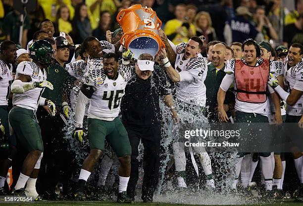 Michael Clay and Bryan Bennett dump the gatorade cooler on head coach Chip Kelly of the Oregon Ducks after their 35 to 17 victory over the Kansas...