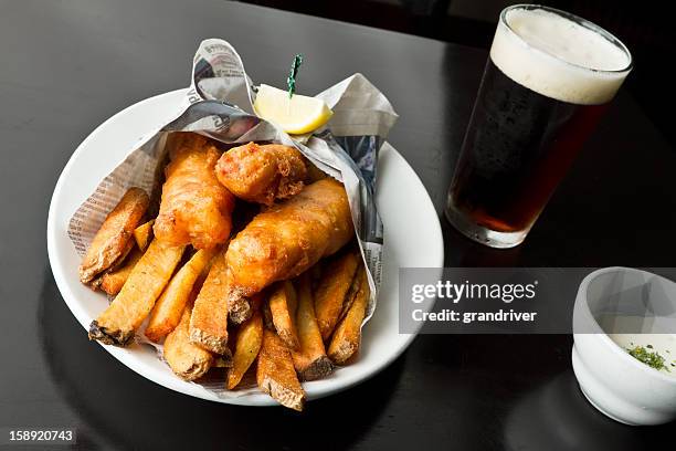 fish and chips with beer - chips on paper stock pictures, royalty-free photos & images