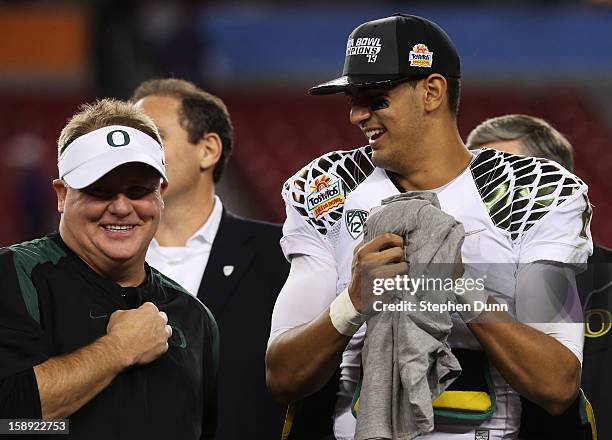 Head coach Chip Kelly celebrates with Marcus Mariota of the Oregon Ducks after their 35 to 17 win over the Kansas State Wildcats in the Tostitos...