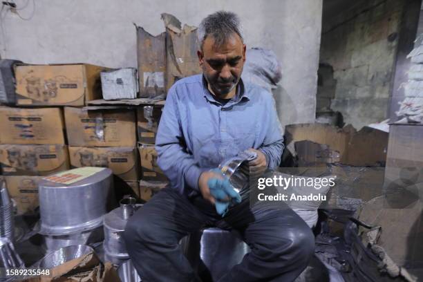 Man works on a process of producing saucepan, transformed by waste cans at the recycling facility in Al Bab district of Aleppo, Syria on August 03,...