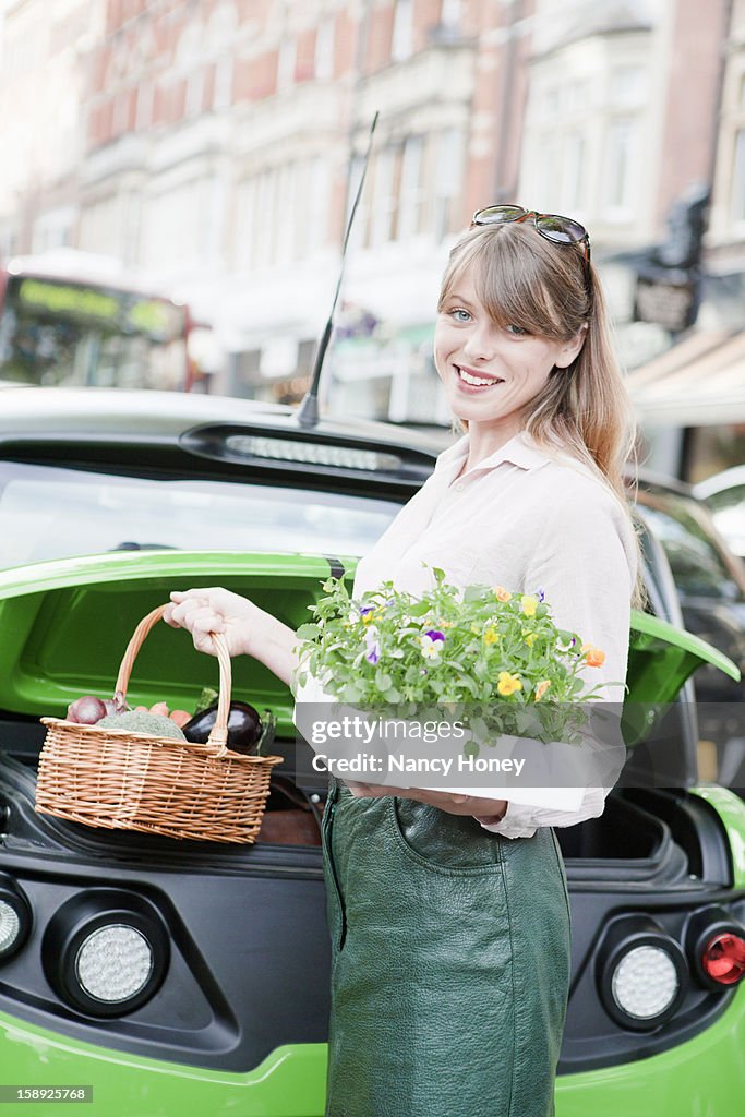 Woman loading produce into car