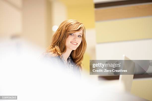 businesswoman using computer at desk - facial expression girl office stock-fotos und bilder