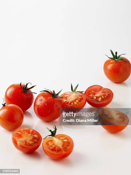 halved plum tomatoes on kitchen counter - eiertomate stock-fotos und bilder