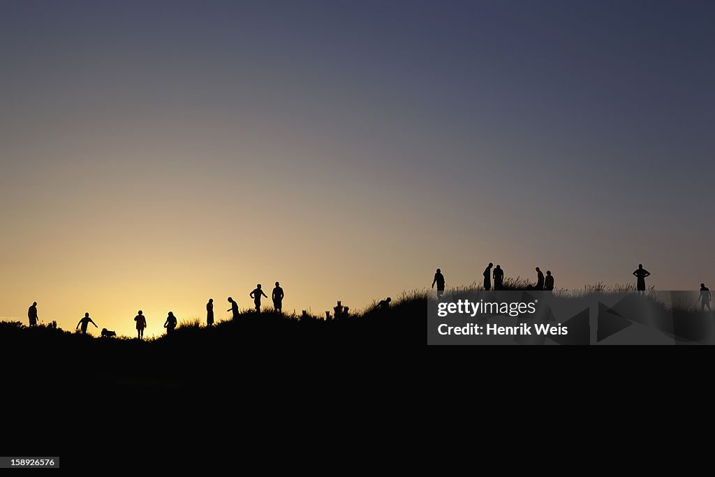 Silhouettes of people on rural hilltops