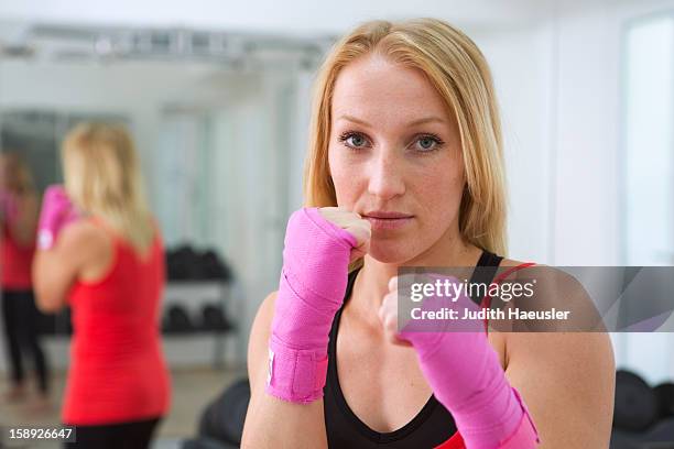 boxer holding fists up in gym - fighting stance 個照片及圖片檔