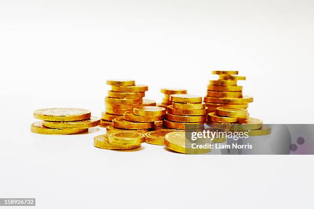 close up of stacks of gold coins - coin stack stock-fotos und bilder