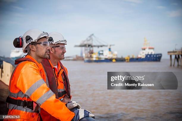 tug workers looking out to sea on tug - dock worker stock-fotos und bilder