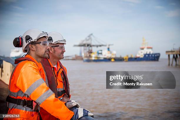 tug workers looking out to sea on tug - harbour stockfoto's en -beelden