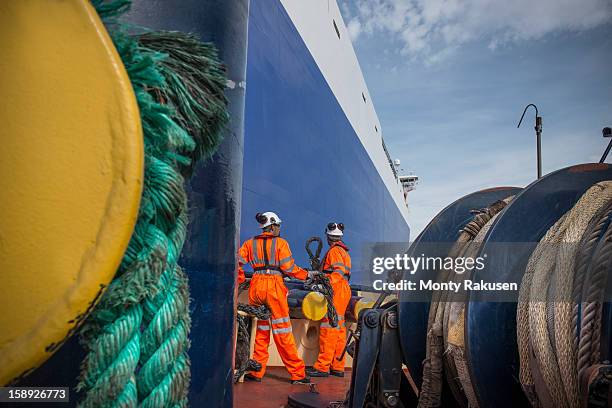 tug workers on tug at sea with ropes in foreground - crew stockfoto's en -beelden