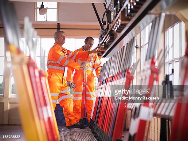 railway signalmen in signal box pulling lever - lever stock pictures, royalty-free photos & images