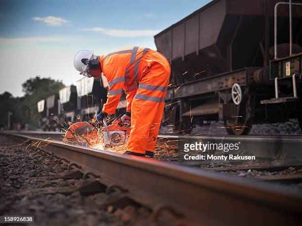 railway worker using grinder to work on railway tracks - rail fotografías e imágenes de stock