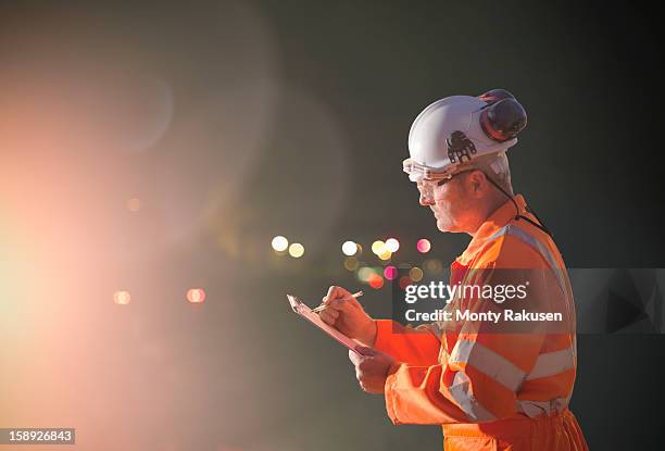 railway worker making notes at night - rail worker stock pictures, royalty-free photos & images