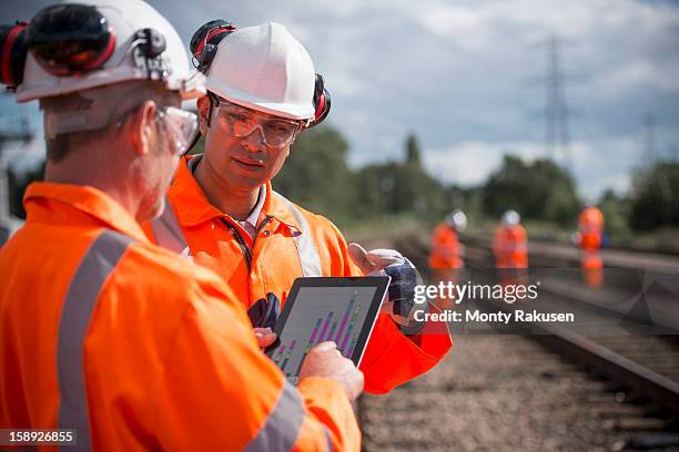 railway workers using digital tablet to discuss work - railroad track stock pictures, royalty-free photos & images