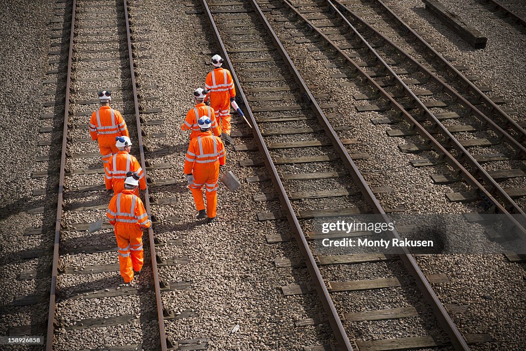 Railway workers walking along railway tracks