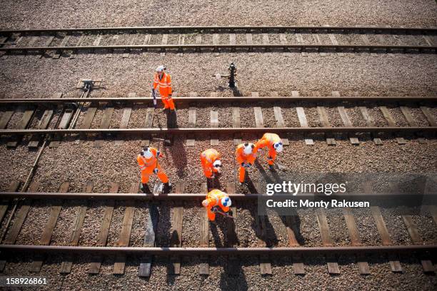 railway workers working on railway tracks, overhead view - vía de tren fotografías e imágenes de stock