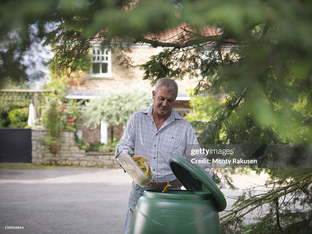 Man putting kitchen waste into compost bin