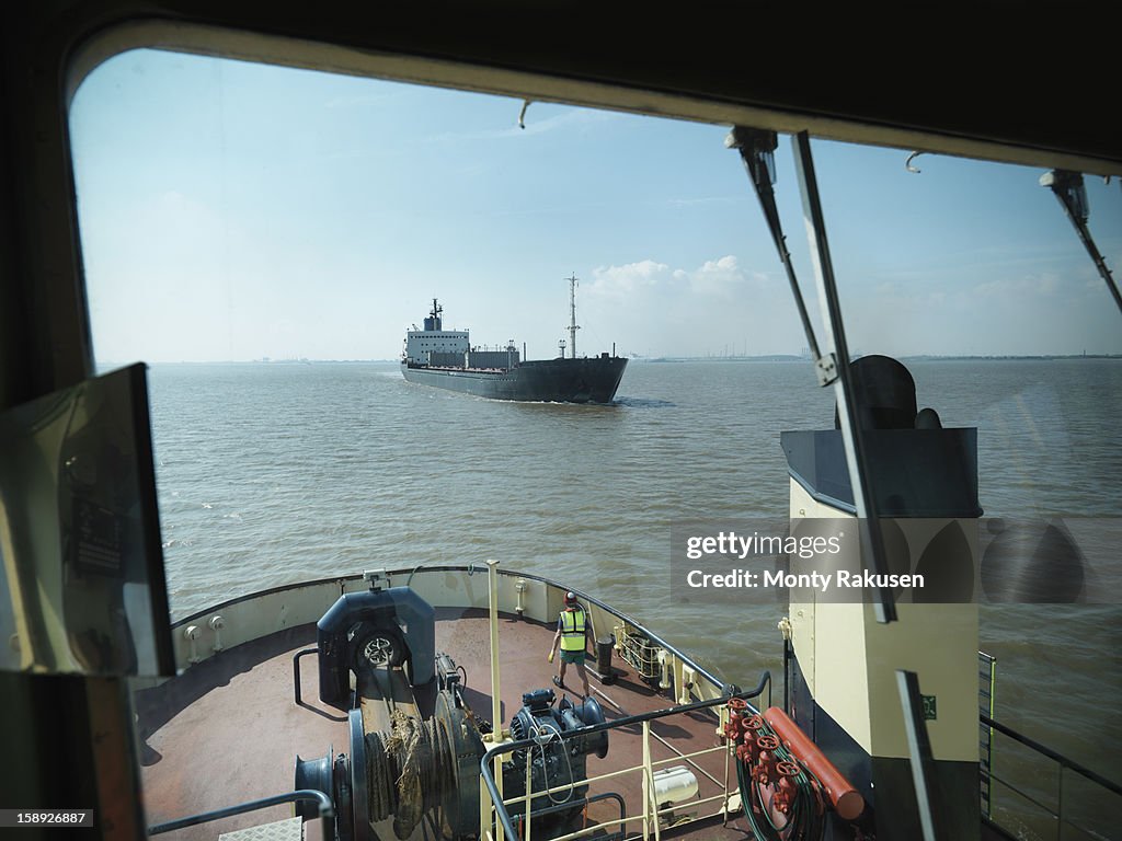View from bridge of tugboat of ship approaching at sea