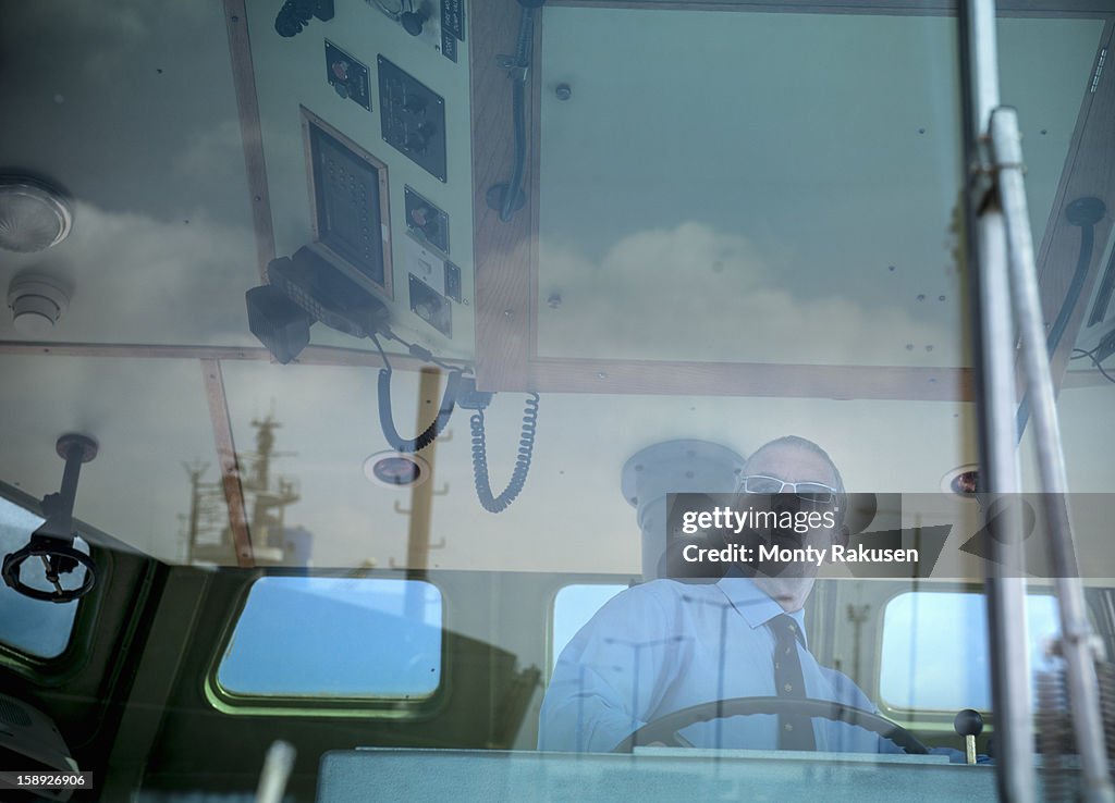 Captain in window of bridge of tugboat at sea