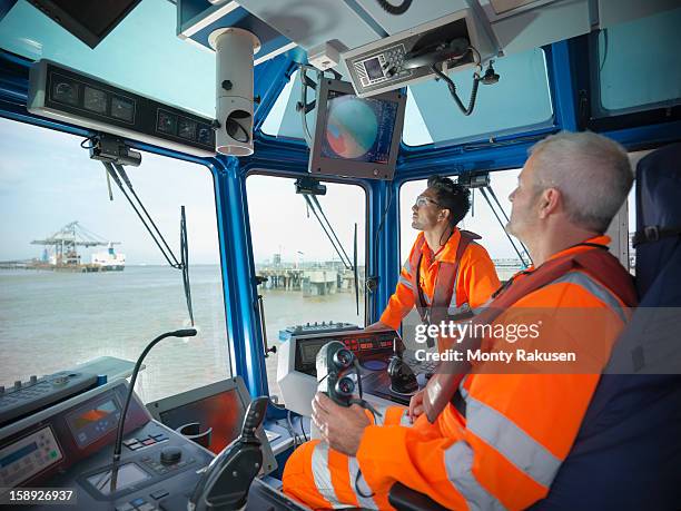 tug workers wearing protective clothing steering tug - tug boat stock-fotos und bilder