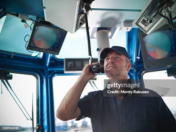 tug captain speaking on radio - boat captain stock pictures, royalty-free photos & images