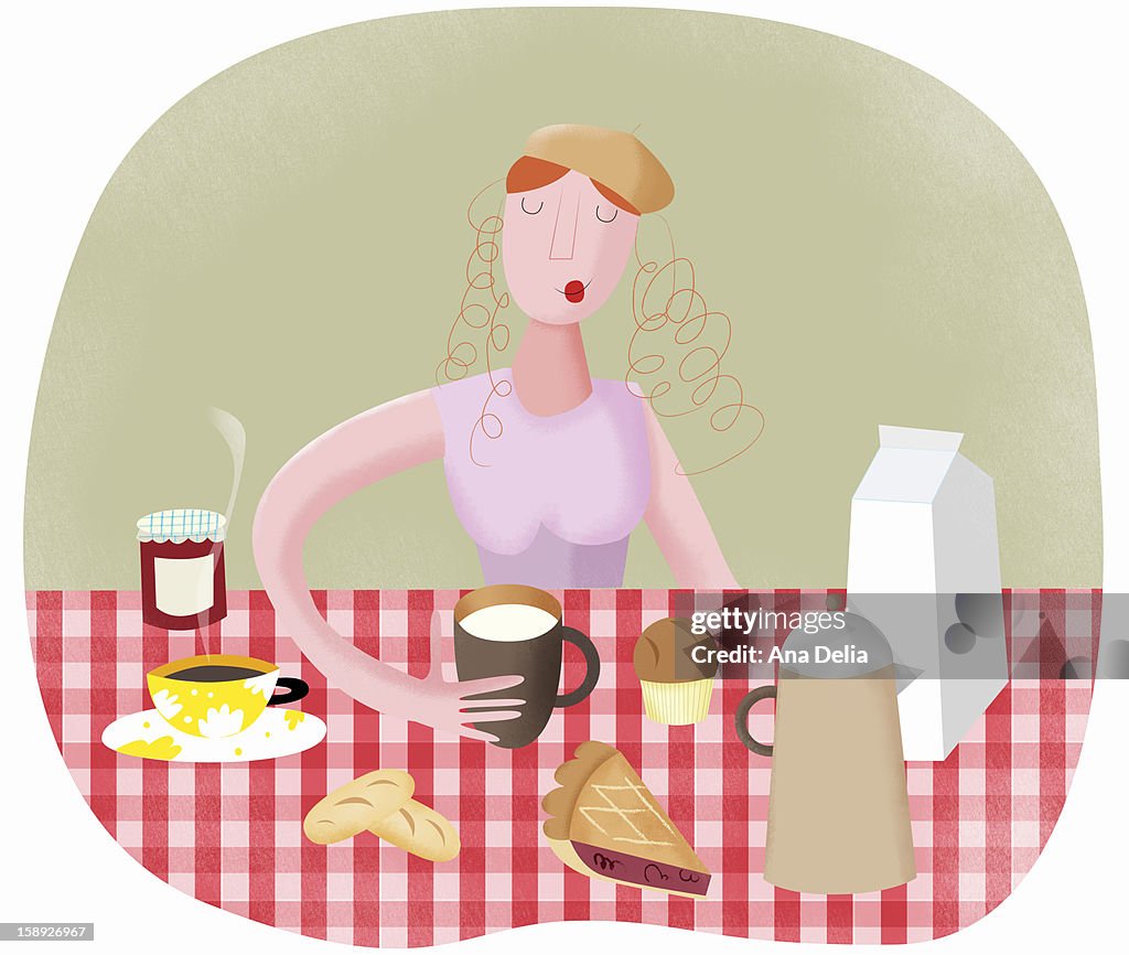 A woman holding a drink with various food on the table