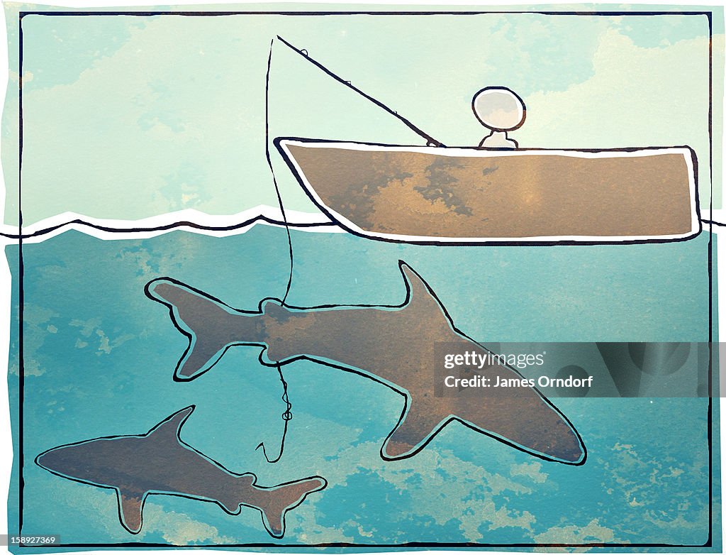 A man fishing with sharks swimming underneath his boat