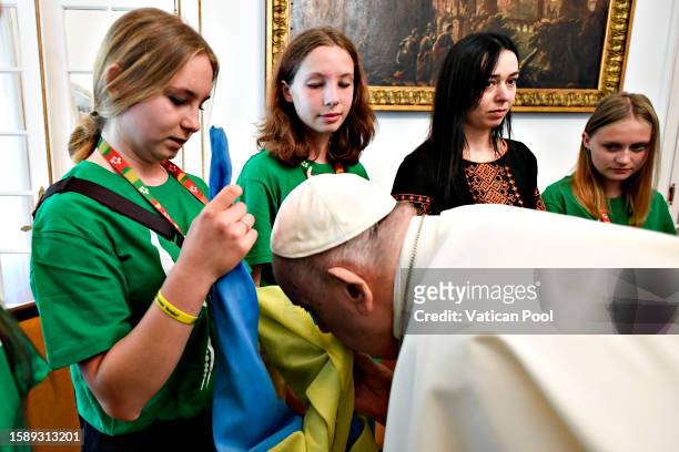 Pope Francis kisses the Ukrainian flag during a meeting with a group of young people from Ukraine at Apostolic Nunciature on August 03, 2023 in...