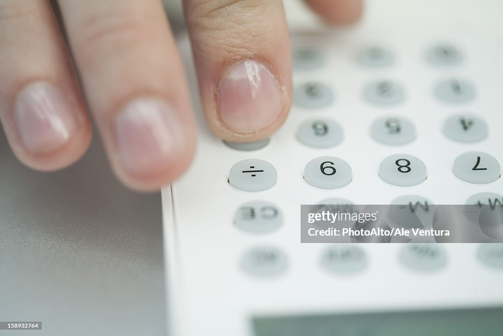 Woman using calculator, extreme close-up
