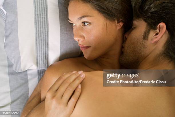 young couple being intimate in bed, woman looking away - comportamento sessuale umano foto e immagini stock