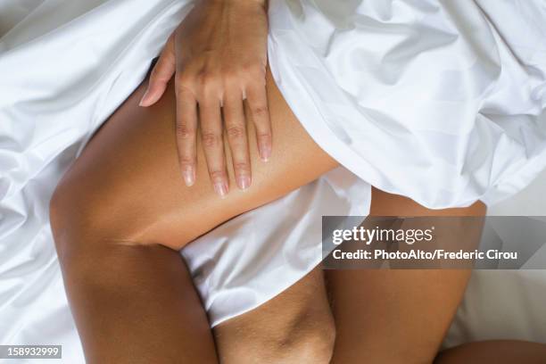 couple's bare legs in bed, cropped - actividad sexual humana imágenes fotografías e imágenes de stock