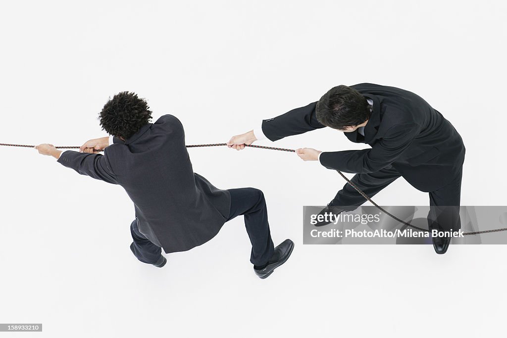Businessmen playing tug-of-war