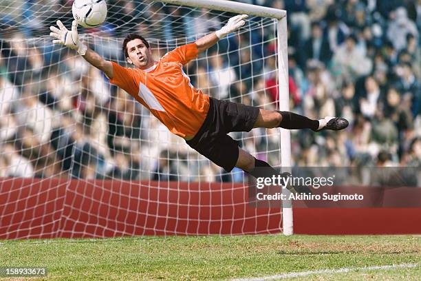 goalkeeper diving for a save - naar de grond duiken stockfoto's en -beelden