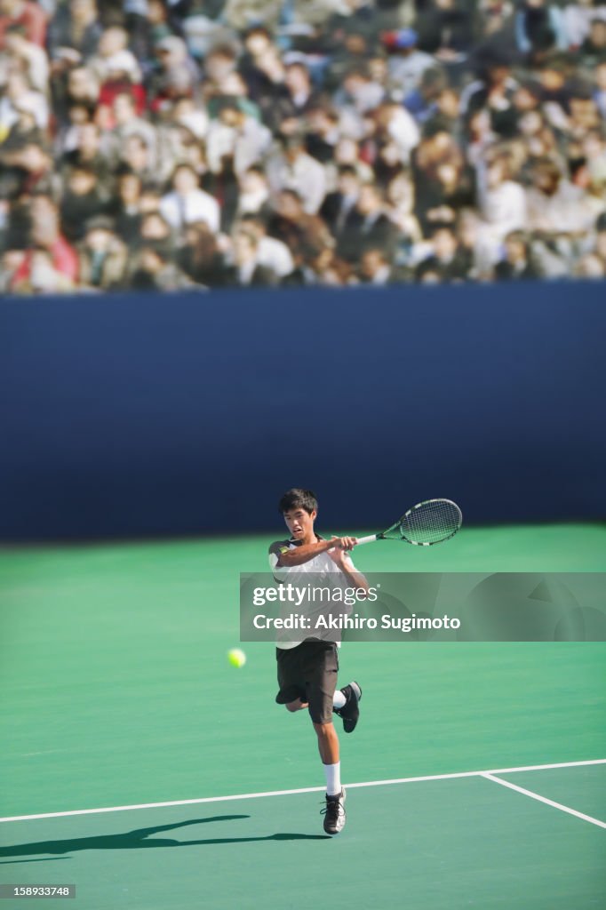 Tennis player hitting forehand return