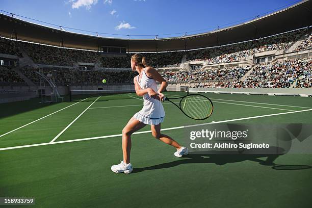 tennis player hitting backhand return - tennis action stock-fotos und bilder
