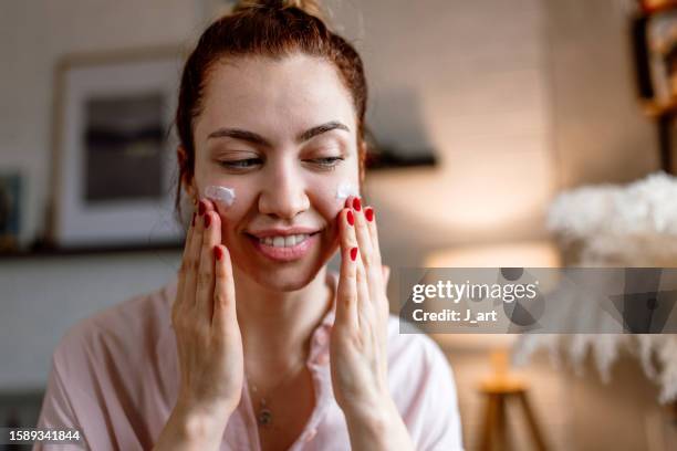 applying face cream for problematic skin. - gezichtscrème stockfoto's en -beelden