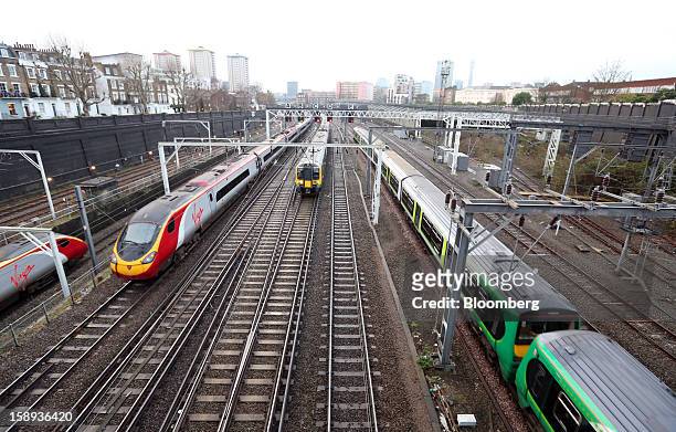 West Coast trains, operated by Virgin Trains, left, and London Midland trains pass outside Euston railway station in London, U.K., on Thursday, Jan....