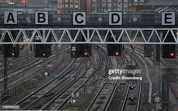 Rail signals stand above railtracks outside Euston railway station in London, U.K., on Thursday, Jan. 3 2013. Rail commuters have been hit by...