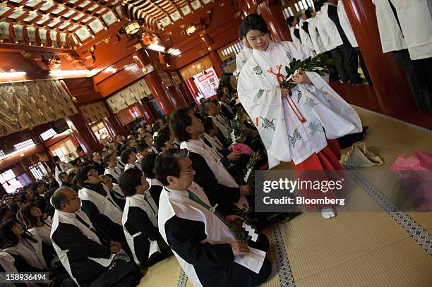 People wearing ceremonial Shinto vests sit in prayer on the first day of business in 2013 at the Kanda Myojin shrine in Tokyo, Japan, on Friday, Jan....