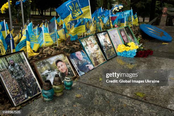 Flowers and candles are left near portraits of fallen Ukrainian soldiers on the Memorial during a commemorative action on the Day of Ukrainian...