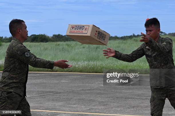 Soldiers load boxes of relief goods for victims of Super Typhoon Doksuri aboard a US V-22 Osprey at Lal-lo Air Base on August 03, 2023 in Lal-lo,...