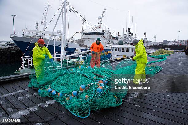 Fishermen arrange their nets beside fishing boats on the harborside in Reykjavik, Iceland, on Wednesday, Jan. 2, 2013. Creditors of Iceland's three...