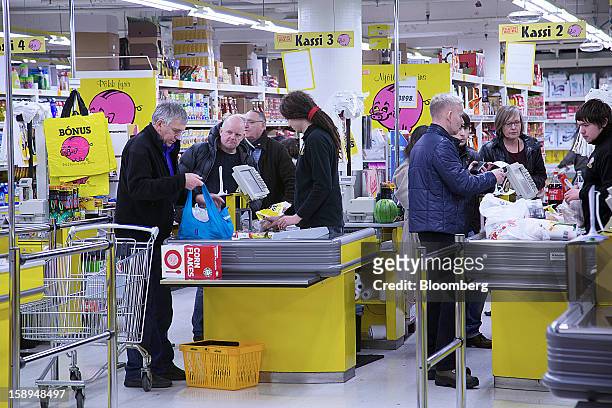 Customers pay for goods at cash desks inside a Bonus grocery store, owned by Baugar Group hf, in Reykjavik, Iceland, on Wednesday, Jan. 2, 2013....