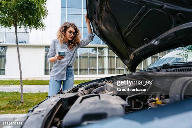 young woman calling road assistance because of the car problems on the street - car problems stock pictures, royalty-free photos & images