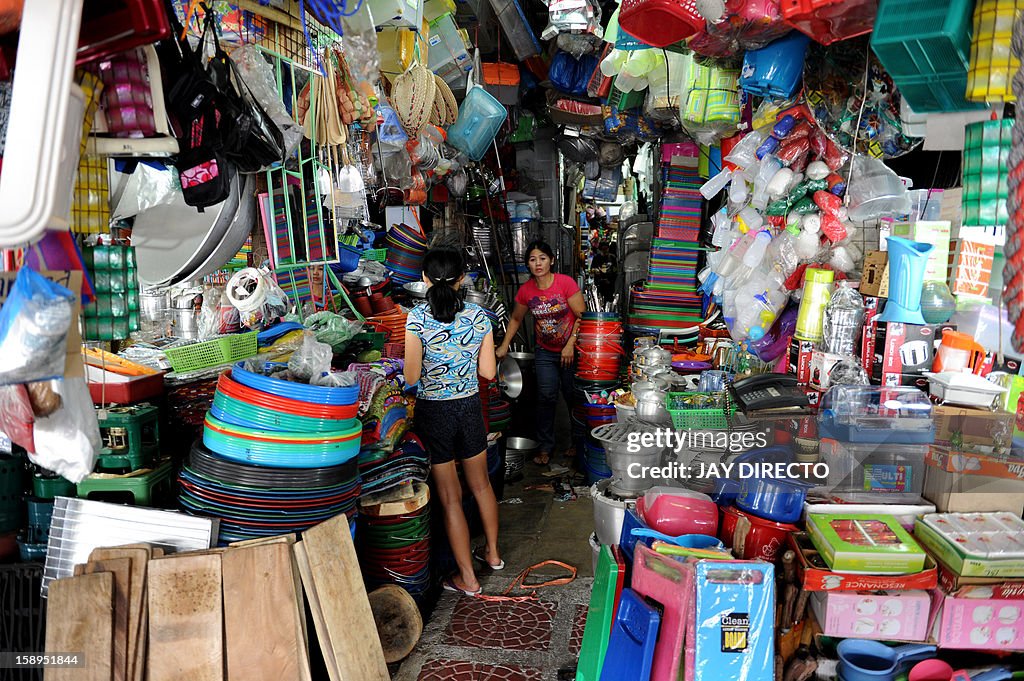 Vendors arrange goods at a general merchandise store in Manila on