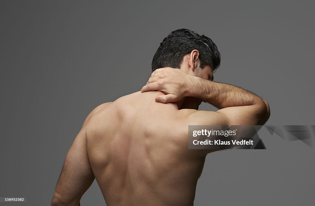 Man having neck pain (rear view)