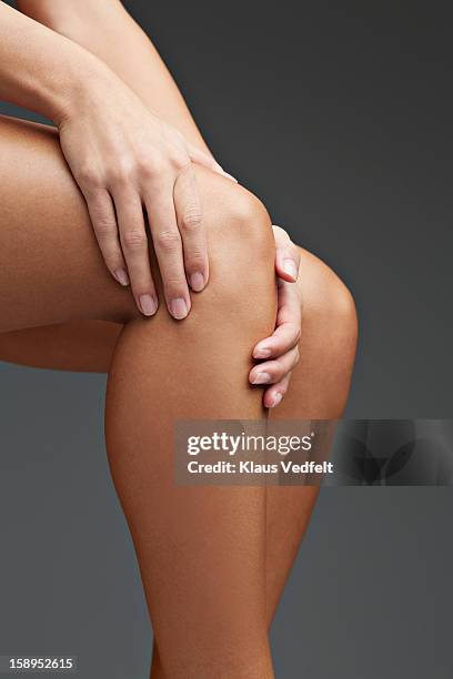 close up of woman having knee pain - female knee pain stock-fotos und bilder